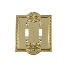 an ornate light switch cover in gold