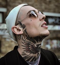 a man with tattoos on his face and neck