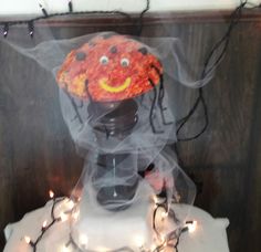 a halloween decoration on top of a table with lights around it and a creepy face in the middle