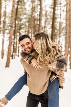 a man and woman hugging in the snow