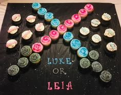 cupcakes are arranged in the shape of an x on a black tablecloth that says luke or leia