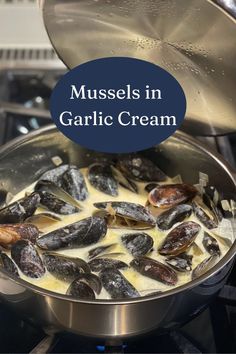 mussels in garlic cream being cooked on the stove with text overlay reading mussels in garlic cream