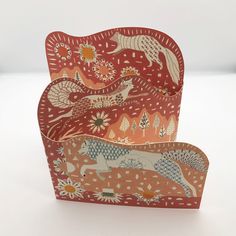 two red boxes with animals and flowers on them