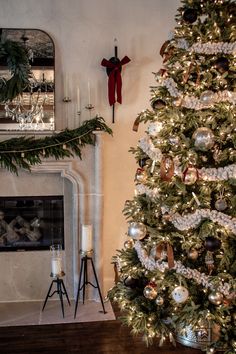 a decorated christmas tree in front of a fireplace