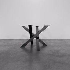 a black and white photo of an x table with two legs on the floor in front of it