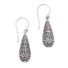 Imagining a pair of dragon tears Balinese artisan Suar Dwipayana designs a striking pair of dangle earrings. Each earring is crafted of sterling silver in the shape of a drop detailed with traditional Balinese motifs and accentuated by a combination of finishes. Traditional Teardrop Earrings As A Gift, Traditional Teardrop Earrings For Gift, Traditional Silver Drop Jewelry, Traditional Sterling Silver Teardrop Earrings As Gift, Spiritual Sterling Silver Teardrop Earrings, Spiritual Teardrop Sterling Silver Earrings, Traditional Handmade Sterling Silver Teardrop Earrings, Ornate Teardrop Earrings With Oxidized Finish, Silver Drop Artisan Earrings