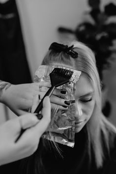 a woman is getting her hair done with a brush