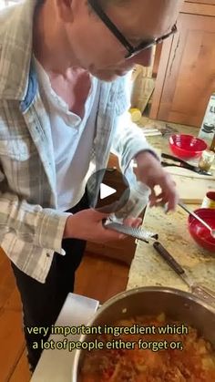 a man in glasses is preparing food on the kitchen counter with a knife and fork