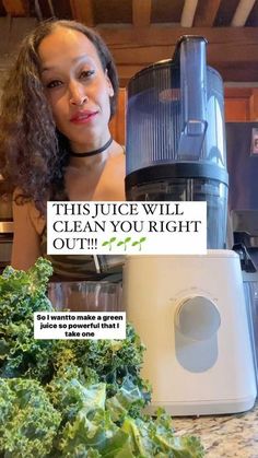 a woman standing in front of a blender filled with green vegetables next to a pile of lettuce