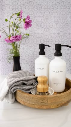 two bottles of hand soap on a wooden tray