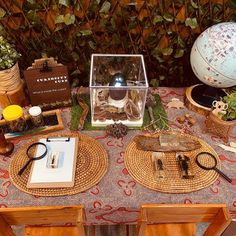 a table topped with lots of assorted items on top of a wooden table covered in plants