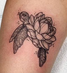 a turtle and flower tattoo on the thigh