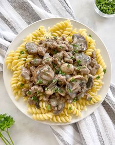 a white plate topped with pasta covered in mushrooms