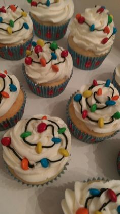 cupcakes with frosting and sprinkles are arranged in a box