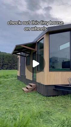 a tiny house on wheels in the middle of a grassy field with text overlay that reads, check out this tiny house on wheels