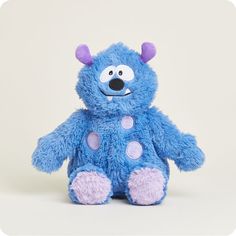 a blue teddy bear with purple spots on it's face and nose, sitting upright