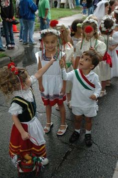 young children dressed in costumes standing on the street