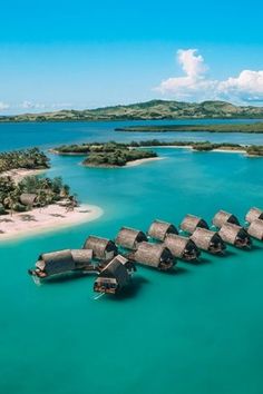 an aerial view of over water huts in the ocean