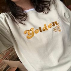 Say hello to your new favourite cute embroidered crewneck sweatshirt!  This Golden shirt, featuring a retro embroidered slogan with flowers, is the cutest and most trendy way to emit all those important boho vibes!  This is the perfect sweater for yourself or as a gift for your friends. * Q U I C K * F A C T S * ✺ 50% cotton, 50% polyester (fiber content may vary for different colors) ✺ Wash and dry on cold (wash inside out, line dry for best results) ✺ We use the softest and most breathable gar Gold Crew Neck Sweatshirt For Fall, Trendy Crew Neck Sweatshirt With Custom Embroidery, Gold Crew Neck T-shirt For Fall, Gold Long Sleeve Sweatshirt For Fall, Golden Shirt, Perfect Sweater, Boho Clothes, Retro Sweater, Stay Golden