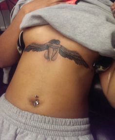 a woman with a bird tattoo on her stomach