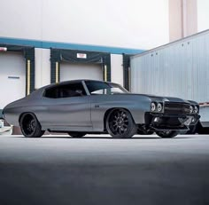 a gray car parked in front of a garage