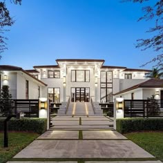 a large white house with lots of windows and stairs leading to the front door area