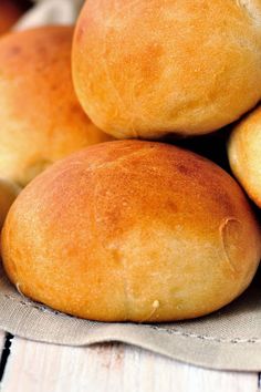 several round bread rolls stacked on top of each other in a pile with linen napkins