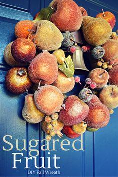 a wreath made out of fruit hanging on a door with the words, sugared fruit diy fall wreath