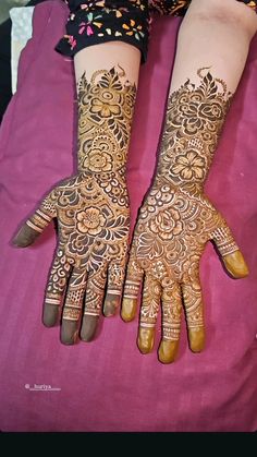 two hands with henna tattoos on them