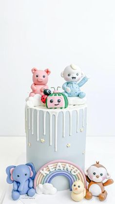 there is a cake decorated with animals and rainbows on the top, along with other toys