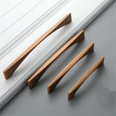 three wooden handles are shown on the side of a window sill, and one is missing