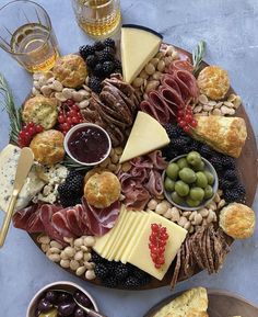 an assortment of cheeses, crackers and meats arranged on a platter