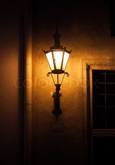 an old fashioned street lamp lit up in the dark