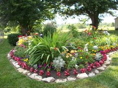 a garden with flowers and rocks in the middle, surrounded by trees on both sides