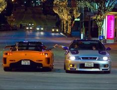 two cars parked on the street at night