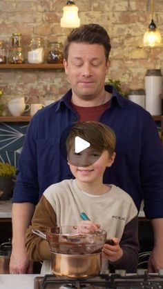 a man standing next to a boy in front of a stove