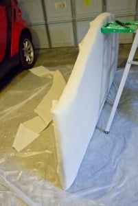 a car parked in a garage next to a white wall with a green sign on it