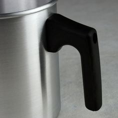 a stainless steel cup with a black handle