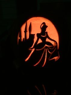 a carved pumpkin with the silhouette of a princess