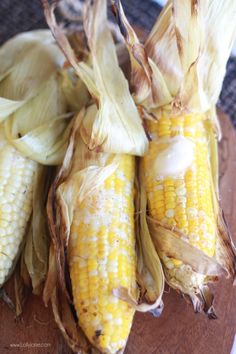 corn on the cob sitting on top of a wooden cutting board