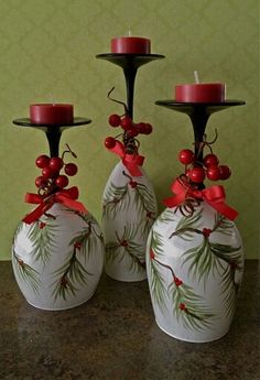 three white vases with red candles on them