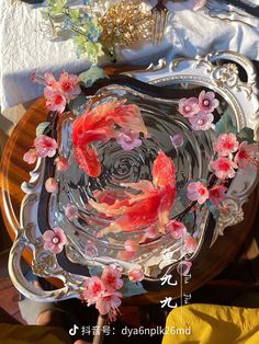 two goldfish in a bowl with pink flowers on it