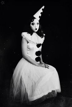 an old black and white photo of a woman in a dress with a cat hat