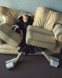 a doll sitting on top of a couch covered in pillows