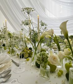 the table is set with flowers, candles and wine glasses for an elegant wedding reception