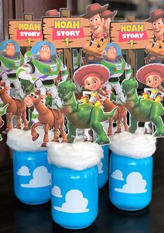 toy story birthday party favors in blue plastic cups with toy story characters on the top