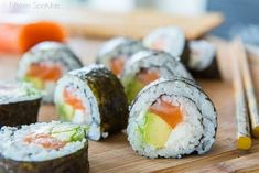 sushi rolls are arranged on a cutting board