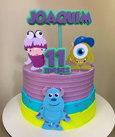 a birthday cake with monsters on it and the number 11 in blue, yellow and purple