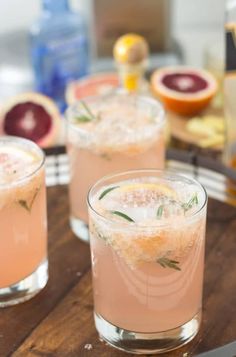 two glasses filled with pink lemonade and garnished with rosemary on the rim