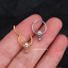 two rings are shown in the palm of someone's hand, one is wearing a nose ring